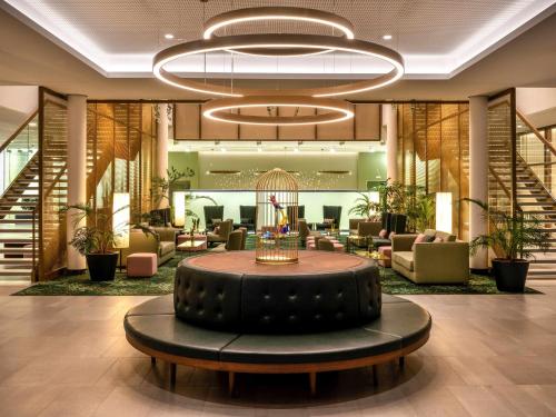 a lobby with a large round table in the middle at Mövenpick Hotel Stuttgart Messe & Congress in Stuttgart