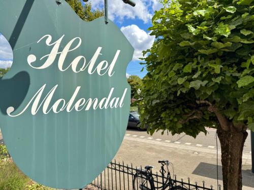 a sign for a hotel adelander next to a tree at Hotel Molendal in Arnhem
