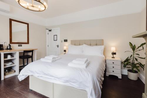a white bedroom with a white bed and a desk at Grace's Guesthouse 68b in Tring
