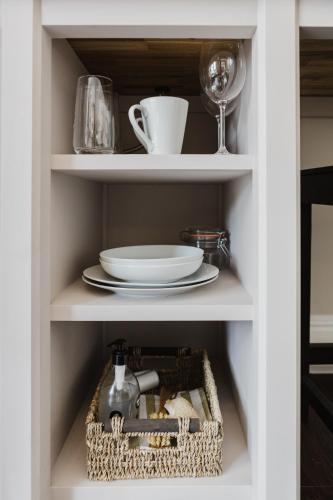 a white cabinet with a plate and a wine glass at Grace's Guesthouse 68b in Tring