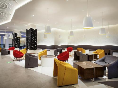 a lobby with colorful chairs and tables at ibis Styles Bandung Grand Central in Bandung