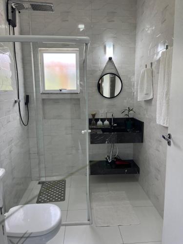 a bathroom with a shower and a toilet and a window at MarisC&LHouse2-Quarto para casal in Bombinhas