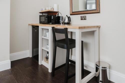 a kitchen island with a black chair at a counter at Grace's Guesthouse 68b in Tring