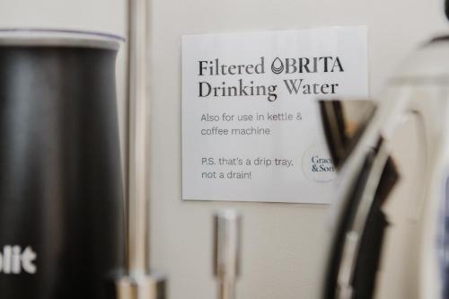 a sign on a refridgerator that reads filtered buffet drinking water at Grace's Guesthouse 68b in Tring