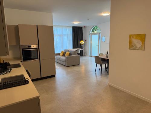 a kitchen and living room with a couch and a table at Schloss Locarno - Self Check-In in Locarno