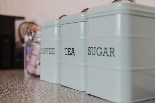 four white containers sitting on top of a counter at Grace's Guesthouse 68b in Tring