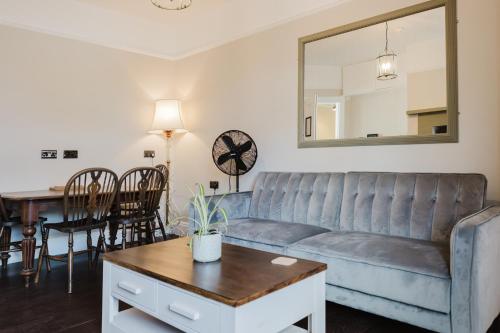 a living room with a couch and a table at Grace's Guesthouse 68b in Tring