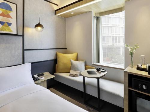 a hotel room with a bed and a window at Ibis Samarinda in Samarinda