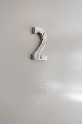 a number two on a wall with a metalswitch at Grace's Guesthouse 68a in Tring