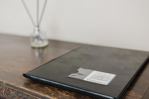 a laptop on a wooden table with a sticker on it at Grace's Guesthouse 68a in Tring