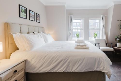 a bedroom with a large white bed with a window at Grace's Guesthouse 68a in Tring
