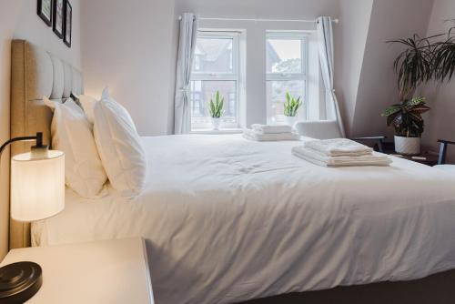 a bedroom with a large white bed with pillows at Grace's Guesthouse 68a in Tring