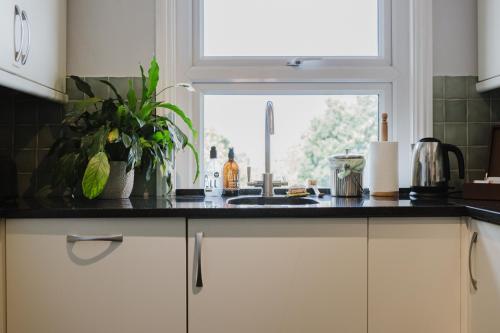 a kitchen counter with a sink and a window at Grace's Guesthouse 68a in Tring