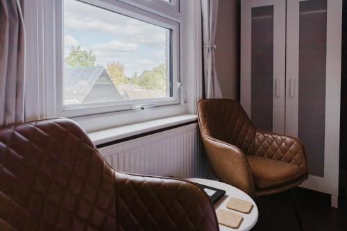 two chairs and a table in a room with a window at Grace's Guesthouse 68a in Tring
