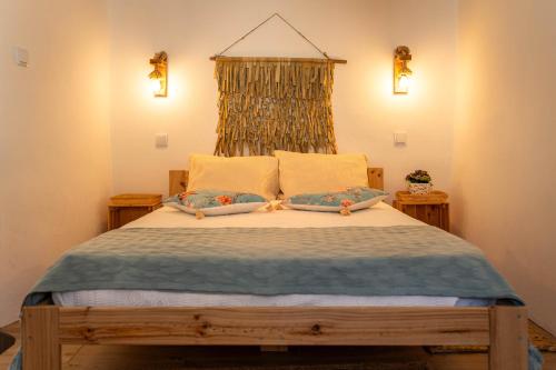 a bedroom with a large bed with two pillows at Casa do Outeiro in São Bartolomeu do Outeiro
