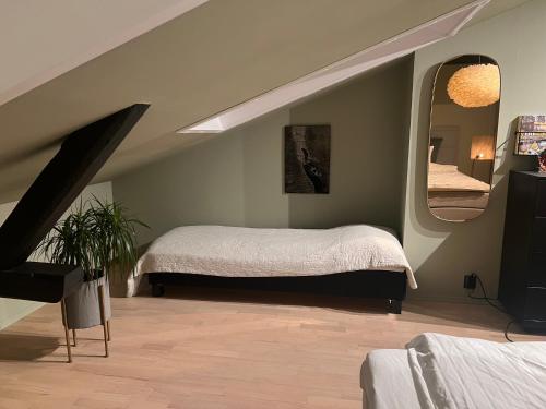 a bedroom with a bed and a large mirror at Stylish Grünerløkka penthouse with rooftop terrace in Oslo