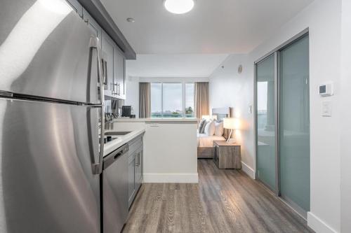 a kitchen with a stainless steel refrigerator in a room at Stylish Studio at Hotel Arya King Bed Full Kitchen City View Balcony and Parking in Miami