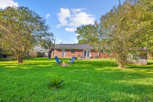 a yard with two blue chairs in the grass at Pace Family Home 1 Mi to Beach and Park! in Pace