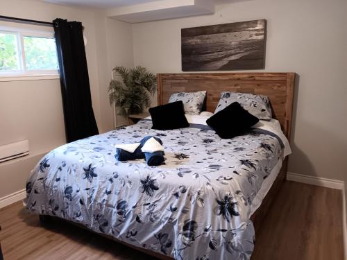 a bed with black and white sheets and pillows at Comox Valley Guest House in Comox