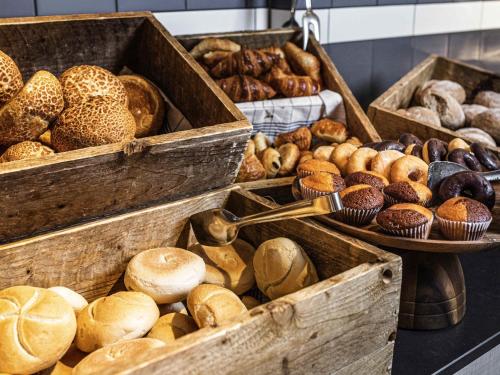 a bunch of different types of breads and pastries at Mercure Antwerp City South in Antwerp