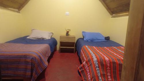 a room with two beds and a dresser and sidx sidx sidx sidx at Yawar inka ayllu challhuay in Colcapampa