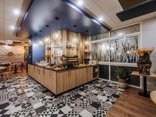 a restaurant with a counter in a room at ibis Styles Ancenis Centre in Ancenis