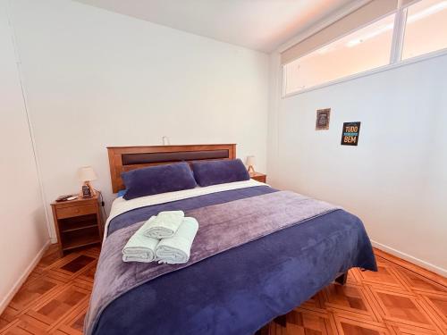 a bedroom with a large bed with towels on it at MAKTVB Europa - Hostal Boutique in Santiago