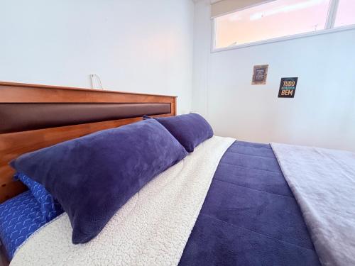 a bedroom with a bed with blue pillows on it at MAKTVB Europa - Hostal Boutique in Santiago