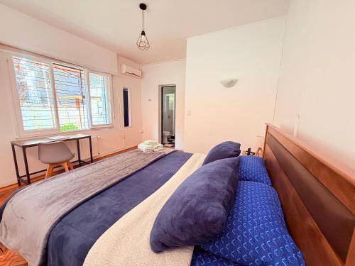 a bedroom with a large bed with blue pillows at MAKTVB Europa - Hostal Boutique in Santiago