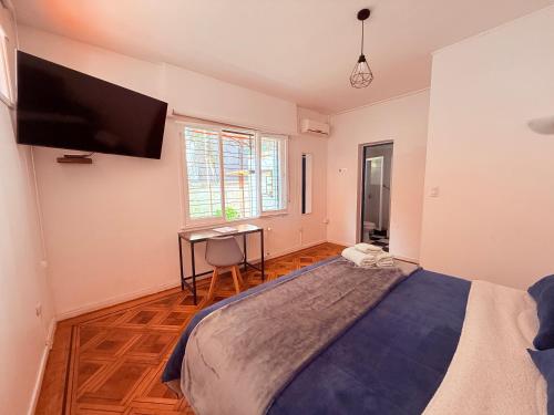 a bedroom with a large bed with a tv on the wall at MAKTVB Europa - Hostal Boutique in Santiago