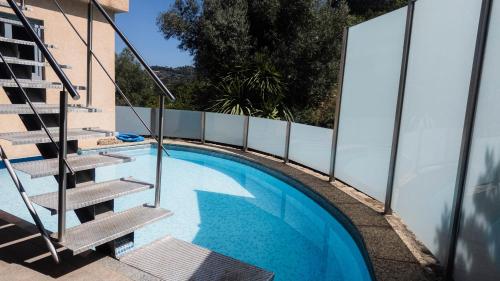 a swimming pool with stairs next to a building at Casa do Lagar in Geres