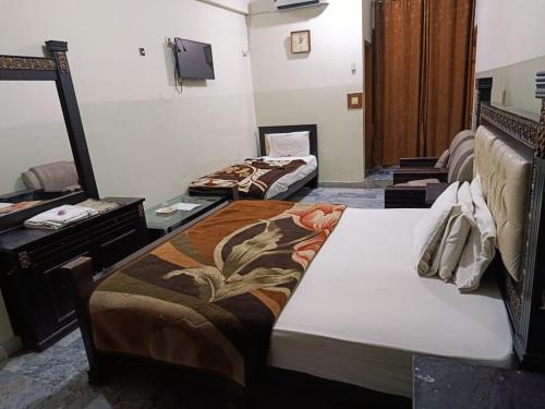 a hotel room with two beds and a mirror at Hotel City Inn in Islamabad