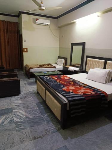 a room with three beds in a room at Hotel City Inn in Islamabad