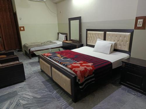 a bedroom with two beds and a mirror at Hotel City Inn in Islamabad