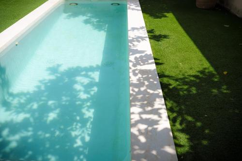 a blue swimming pool in a yard with grass at Villa Yahualli - Alberca Privada - Punta Pérula in Pérula