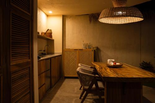 a kitchen with a wooden table and chairs in it at Villa Yahualli - Alberca Privada - Punta Pérula in Pérula