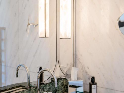 a bathroom sink with two faucets and a mirror at Mondrian Cannes in Cannes