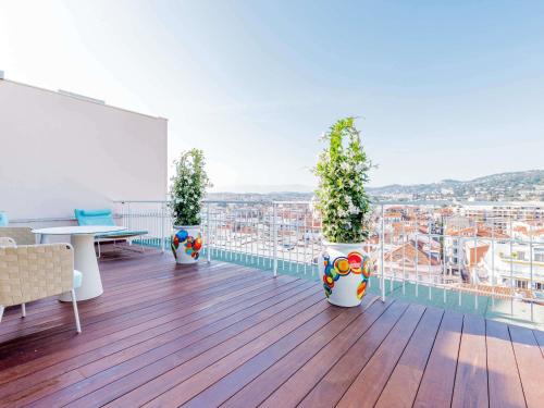 a balcony with three potted plants on a building at Mondrian Cannes in Cannes