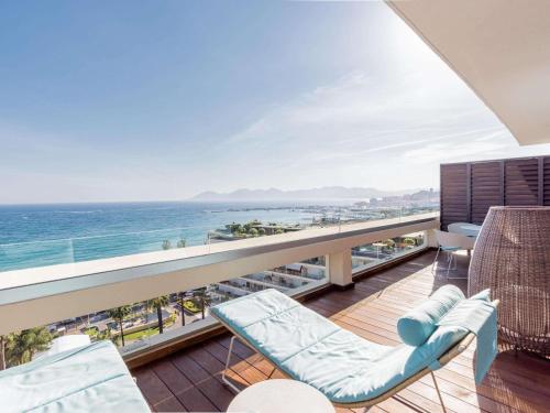a balcony with chairs and a view of the ocean at Mondrian Cannes in Cannes