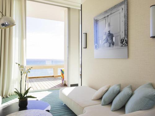 a living room with a couch and a view of the ocean at Mondrian Cannes in Cannes