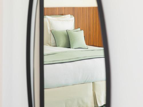 a reflection of two beds with pillows in a mirror at Mondrian Cannes in Cannes