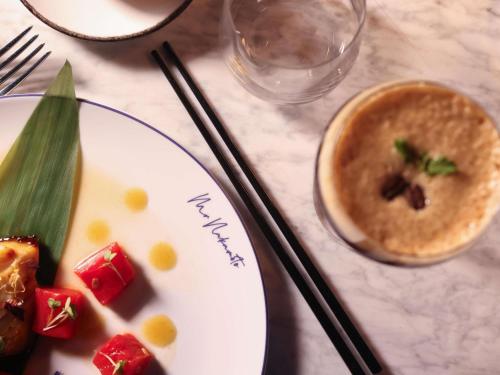 a table with a plate of food and a bowl of soup at Mondrian Cannes in Cannes
