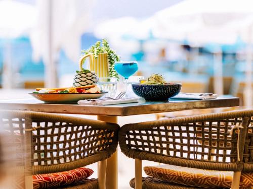 a table with a plate of food and two chairs at Mondrian Cannes in Cannes