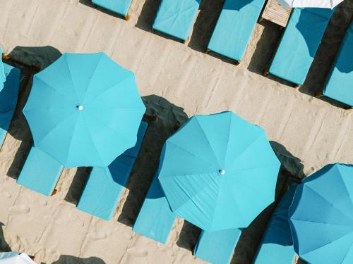 an overhead view of blue umbrellas on a beach at Mondrian Cannes in Cannes