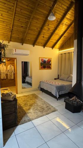 a bedroom with a bed and a mirror at Pousada dos Canyons - chalé 01 in Praia Grande