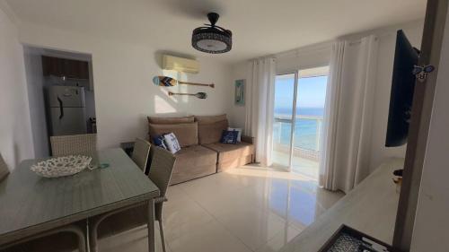 a living room with a couch and a table at Apartamento com Prédio Frente Mar in Praia Grande