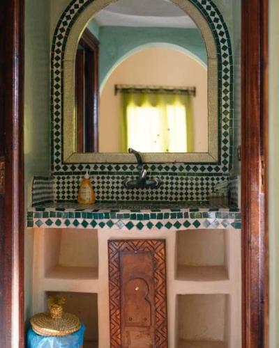 a bathroom with a sink and a mirror at Merzouga Hous in Merzouga