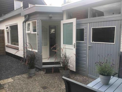 a gray house with potted plants in front of it at Apartment Little Belvedère with private garden in Bergen