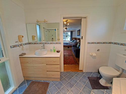 un baño con lavabo e inodoro en North Durras Beach Cottage, en Durras