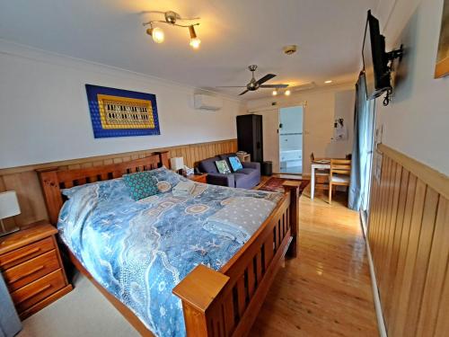 Un dormitorio con una cama y una sala de estar. en North Durras Beach Cottage, en Durras